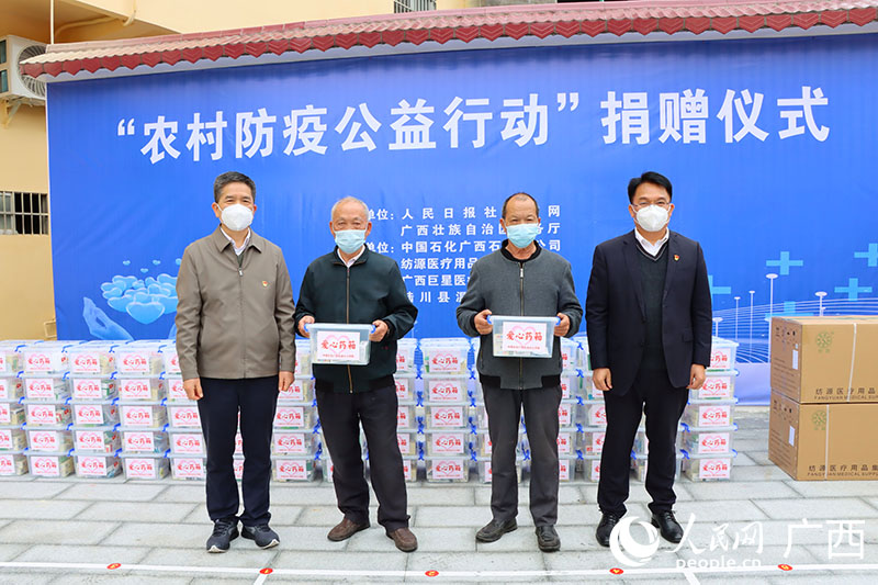 中國(guó)石化廣西石油分公司三級(jí)協(xié)理員、工會(huì)副主席黃家華（左）和中國(guó)石化廣西石油分公司總經(jīng)理助理韋漢前（右）向村民發(fā)放防疫物資。人民網(wǎng) 付華周攝