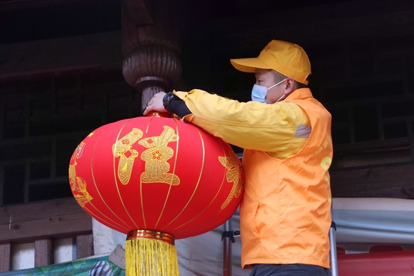 志愿者更換三團(tuán)村鼓樓燈籠?？氯和z