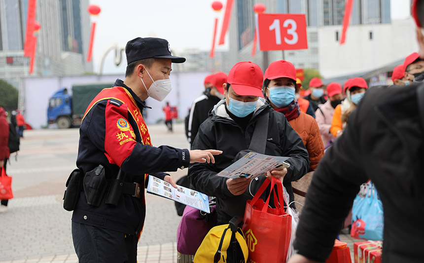 在進站口發(fā)放出行安全注意事項宣傳單。胡玄德攝