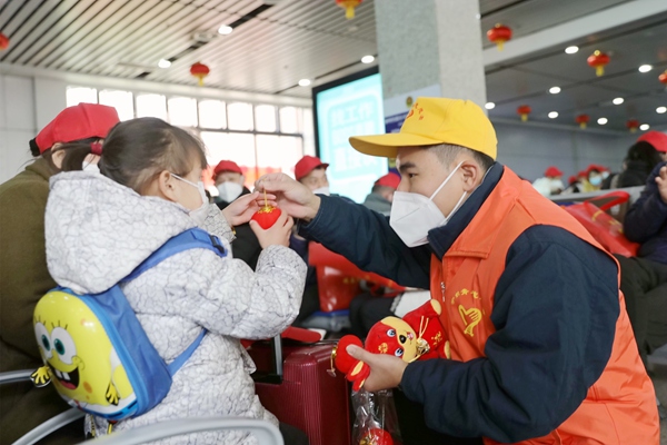 青年志愿者為務(wù)工專列旅客發(fā)放小燈籠等節(jié)日物品。陳雨雨攝