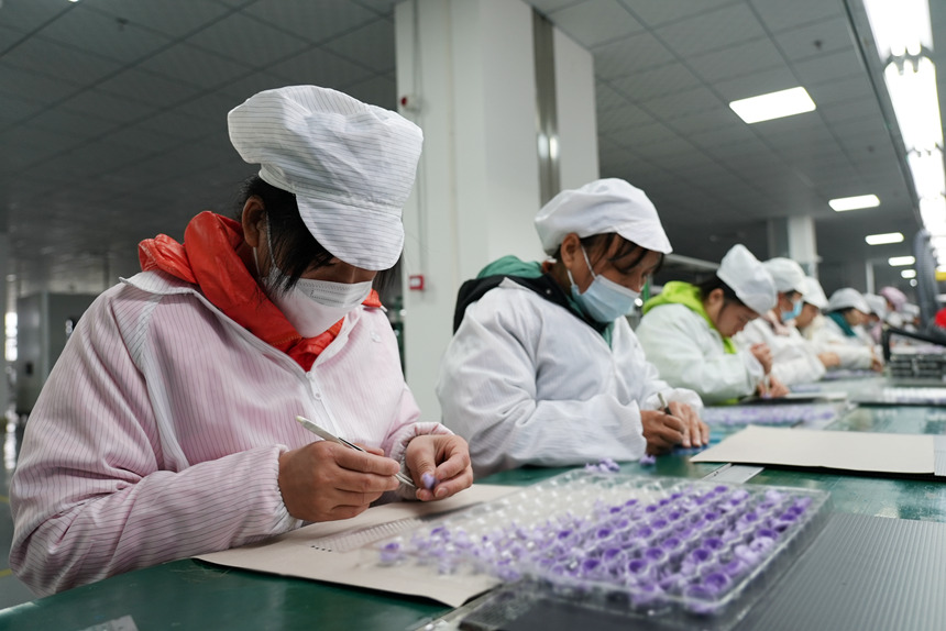 生產(chǎn)流水線上，工人加工產(chǎn)品。