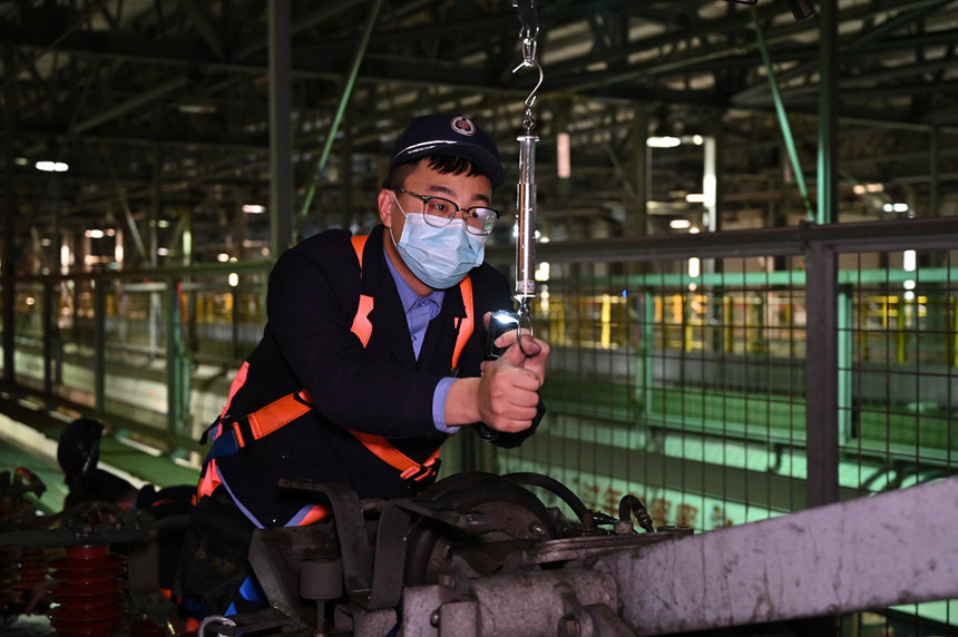 圖為地勤機(jī)械師對車頂受電弓進(jìn)行拉力試驗(yàn)