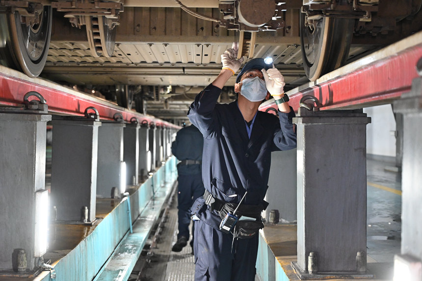 圖為地勤機(jī)械師檢查車底走行部