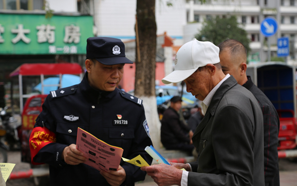民警給群眾發(fā)放并講解防詐騙資料。