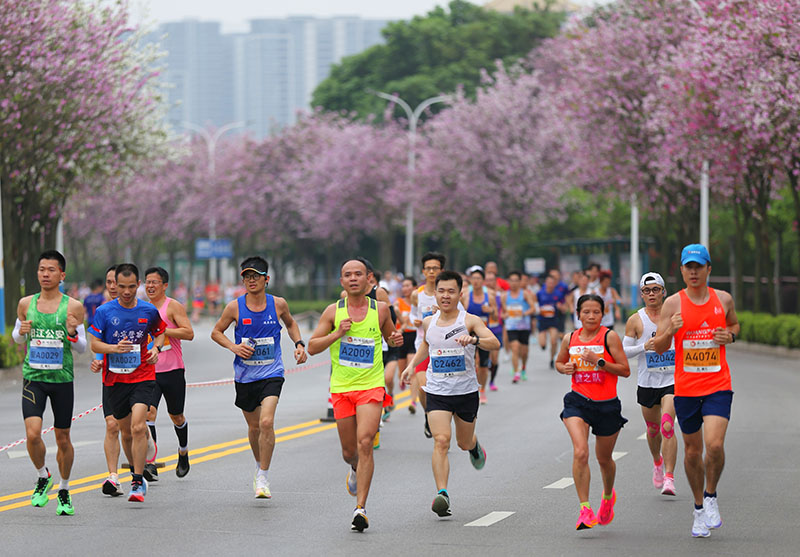 參賽選手在紫荊花道中奔跑。王緝寧攝
