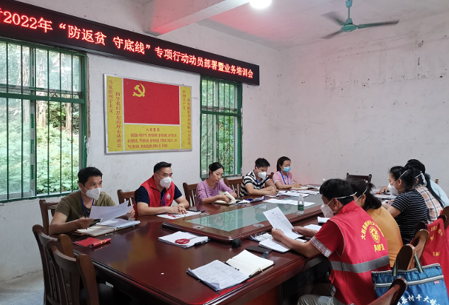 伍章余（左二）與念典村“兩委”班子開會。許倩攝