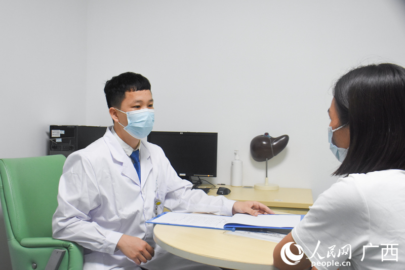 寧以幸（左一）與患者家屬溝通講解病情。人民網(wǎng) 王功孝攝