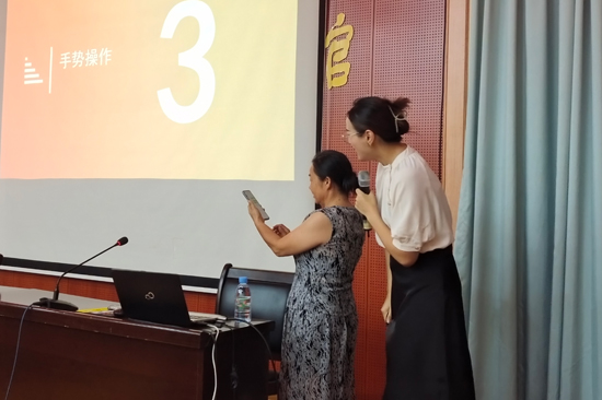 志愿者在向老年人講解智能手機使用方法。橫州市團委供圖
