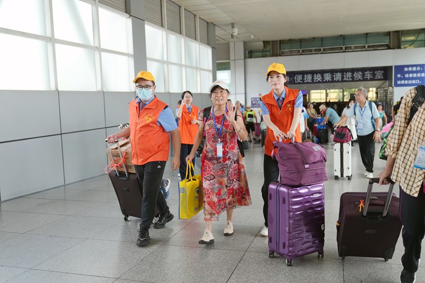 鐵路志愿者引導(dǎo)旅客進(jìn)站乘車。蘭軻艨攝