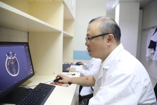 劉克勤在查看患者病情。自治區(qū)衛(wèi)生健康委供圖