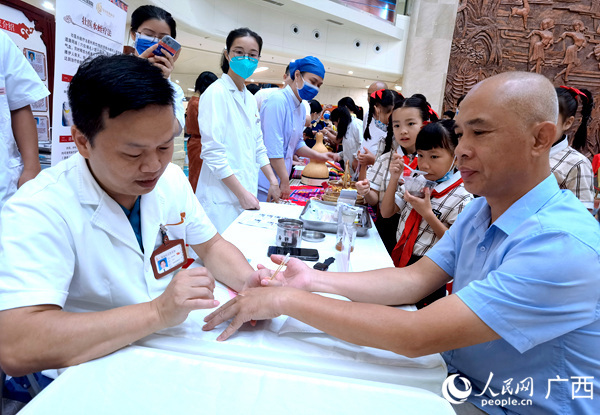 潘明甫為前來(lái)就診的市民針灸。人民網(wǎng)記者 陳燕攝