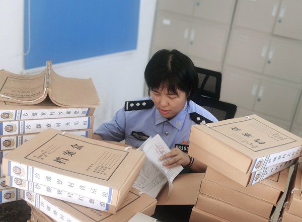 戶籍民警在翻找紙質(zhì)檔案為群眾尋找已故親人照片