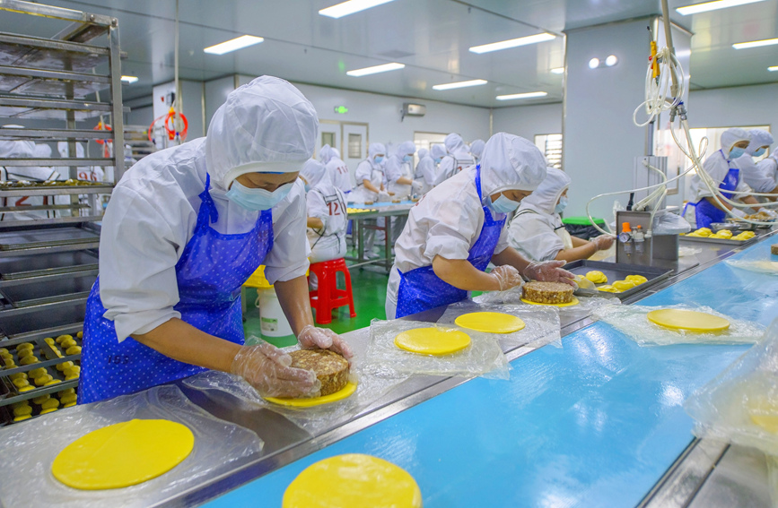 工作人員正在生產(chǎn)線上生產(chǎn)月餅。徐紹榮攝