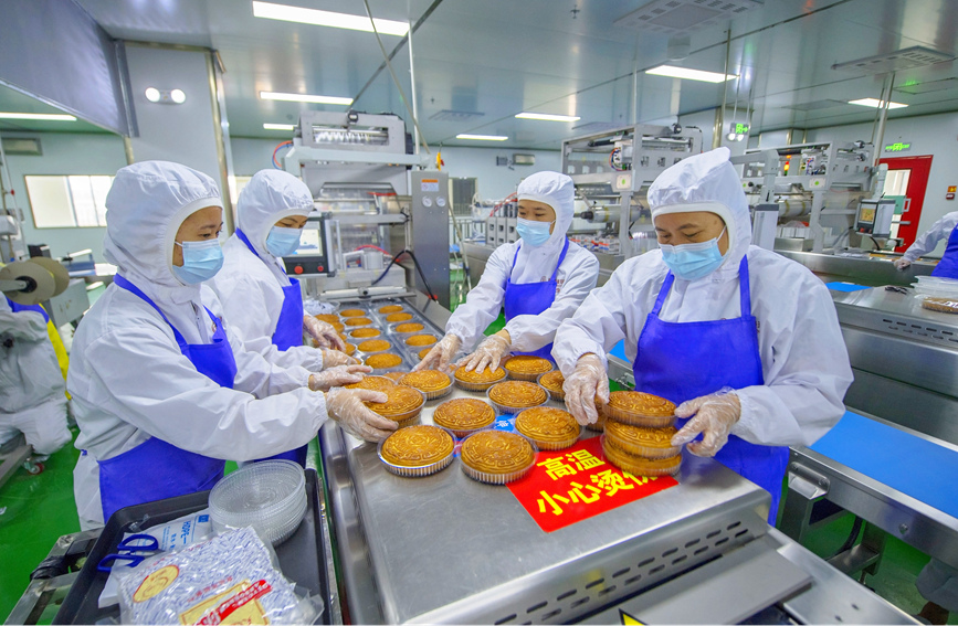 工作人員正在生產(chǎn)線上生產(chǎn)月餅。徐紹榮攝