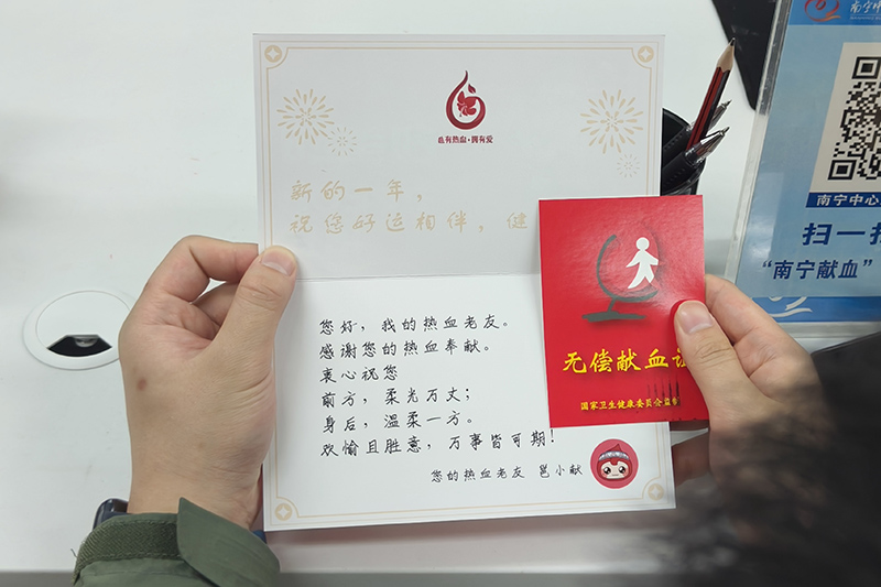 覃天虹獻(xiàn)血后領(lǐng)取無償獻(xiàn)血證。孫赟飛攝