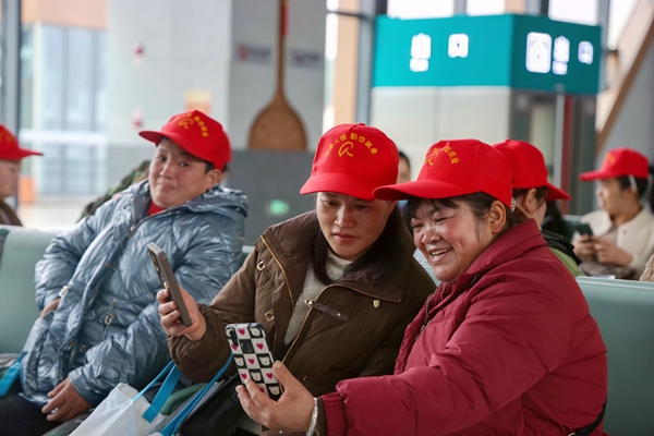 務(wù)工人員在候車(chē)時(shí)與家人視頻通話(huà)。封榮權(quán)攝