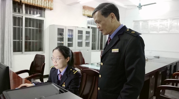 曾南平和謝莉平在辦公室核對貨物信息（林鶴 攝）.jpg