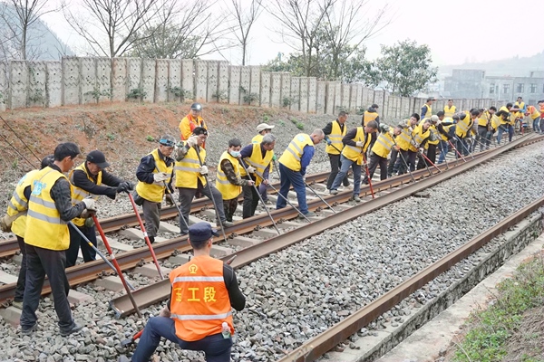 職工合力進(jìn)行線路撥軌作業(yè)。王冠杰攝
