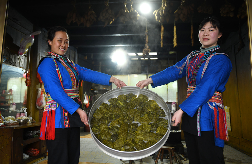 瑤族婦女在展示剛蒸熟出爐的艾粑。潘志祥攝