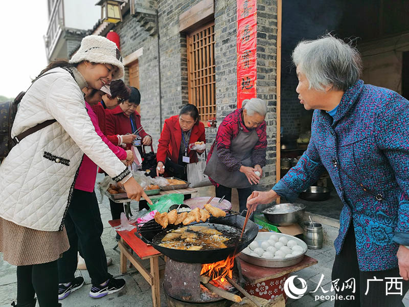 柳州市民在魚峰區(qū)白沙鎮(zhèn)購買當(dāng)?shù)靥厣〕浴Ｈ嗣窬W(wǎng) 付華周攝
