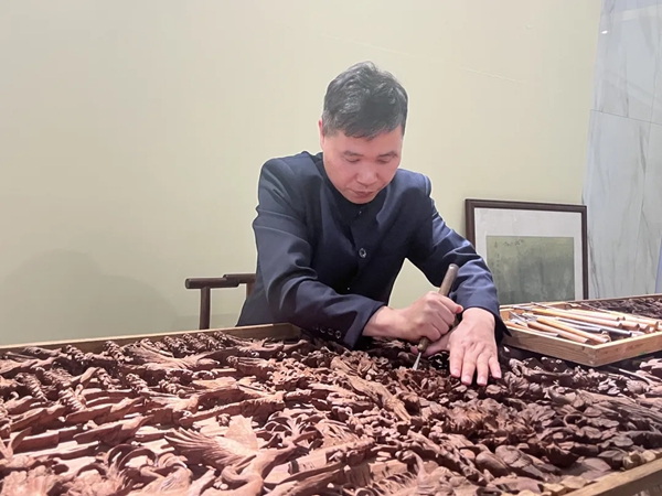 “廣西工藝美術大師”、玉林正龍木雕非遺傳承人黃志龍在現(xiàn)場雕刻。玉州區(qū)委宣傳部供圖