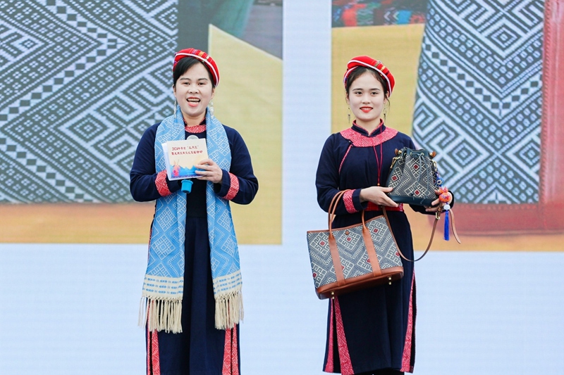 李素英（左一）及其女兒展示壯錦文創(chuàng)新品。龍州縣委宣傳部供圖