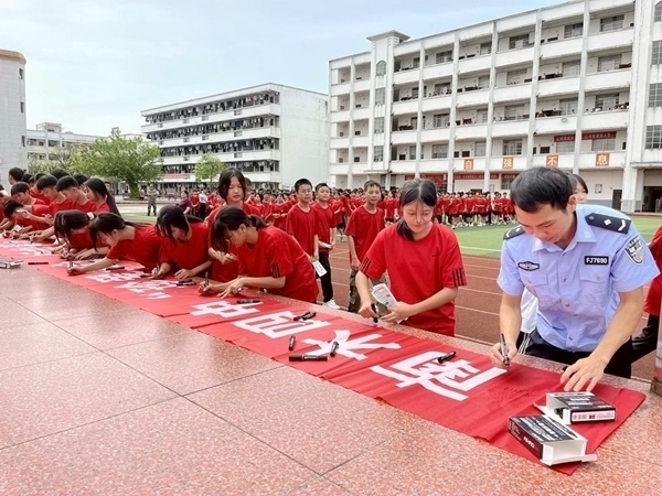 圖為 學(xué)生在橫幅上簽字表達(dá)拒絕毒品的決心.jpg