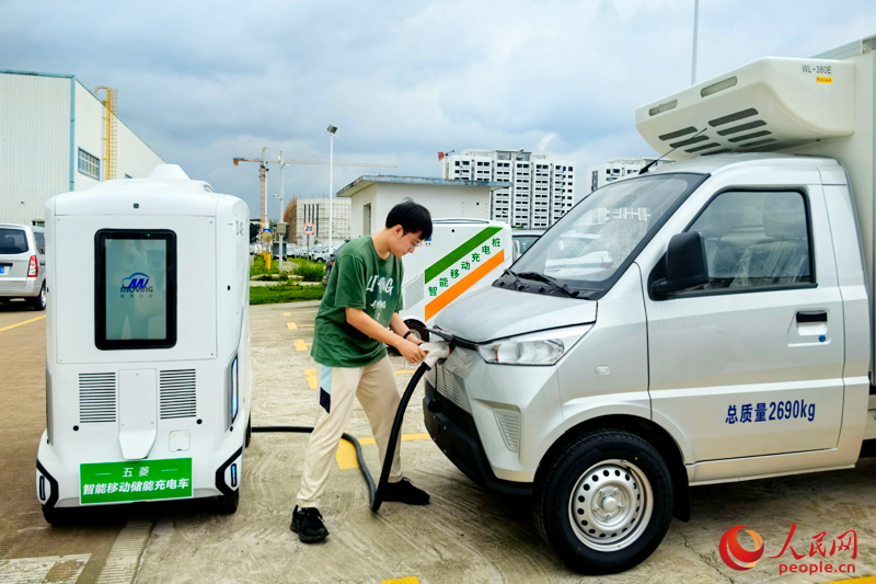 工作人員使用智能移動儲能充電車給新能源汽車充電。人民網(wǎng) 付華周攝