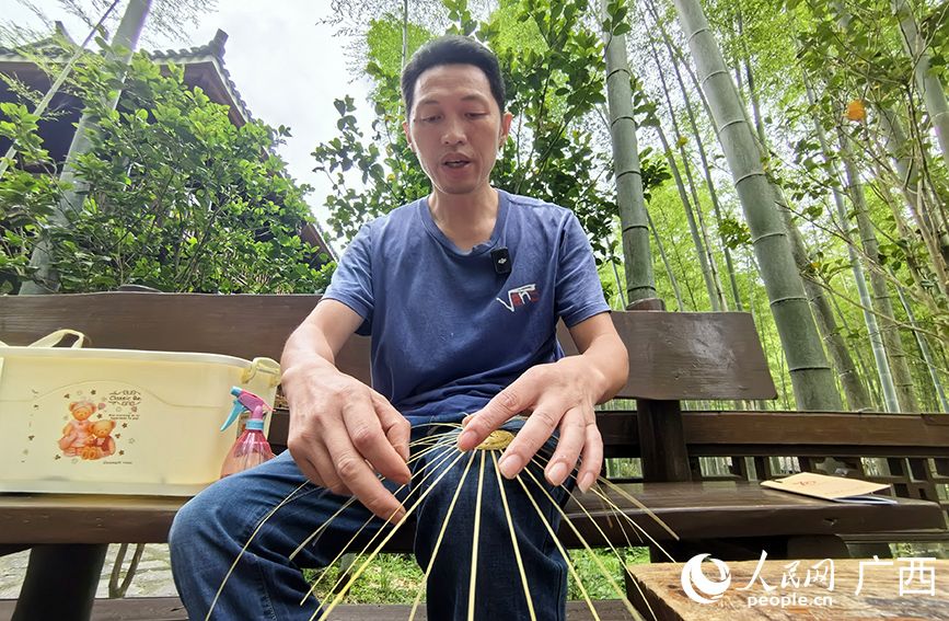 馮文兵在編織的竹工藝品。人民網(wǎng) 付華周攝