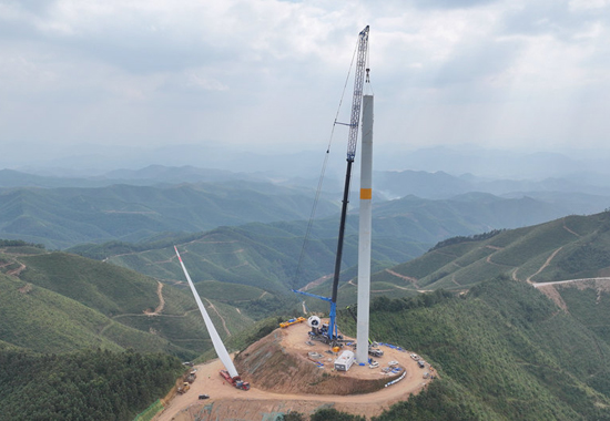 工人們正穩(wěn)步有序地進(jìn)行風(fēng)電機(jī)組的吊裝作業(yè)