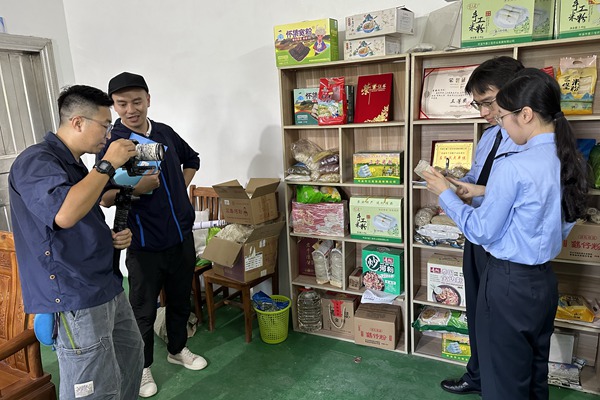 圖為黎子暉（左二）和創(chuàng)作團隊在岑溪市糯垌鎮(zhèn)拍攝制作基層稅務(wù)分局的日常工作宣傳稿。_副本