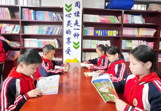 12月6日，新州鎮(zhèn)新街安置點農(nóng)家書屋開展閱讀分享活動，學生們正在認真閱讀。王志春攝