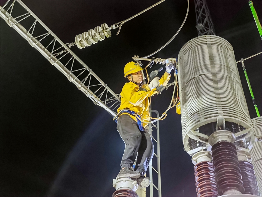 變電站值班員在檢修變電所抗雷線圈線夾。古敬光攝