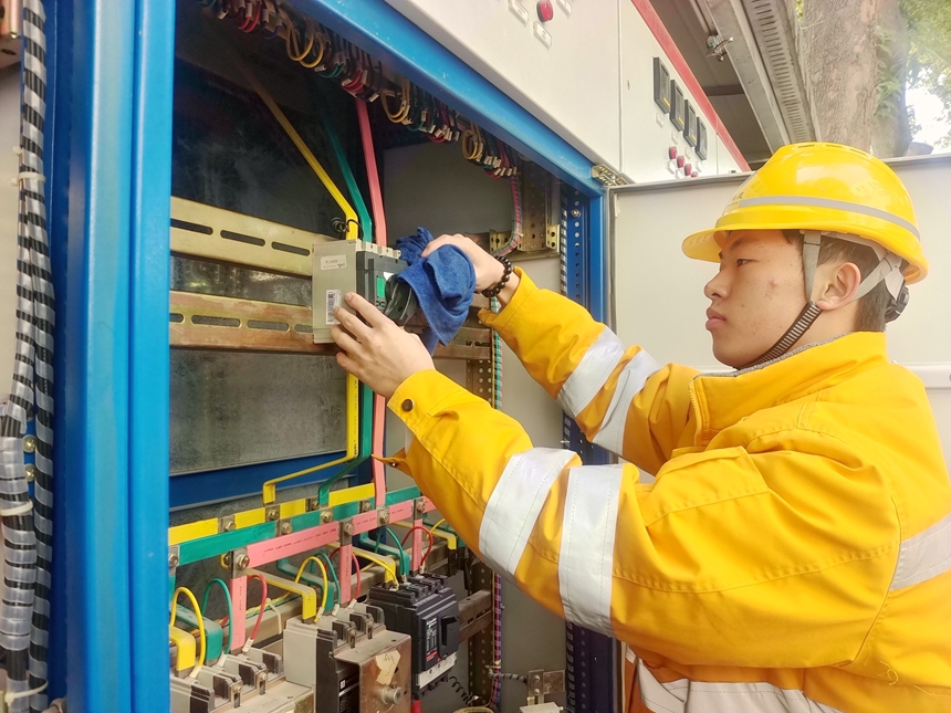青年電力線路工在擦拭維護變壓器箱變設備。申衛(wèi)平攝