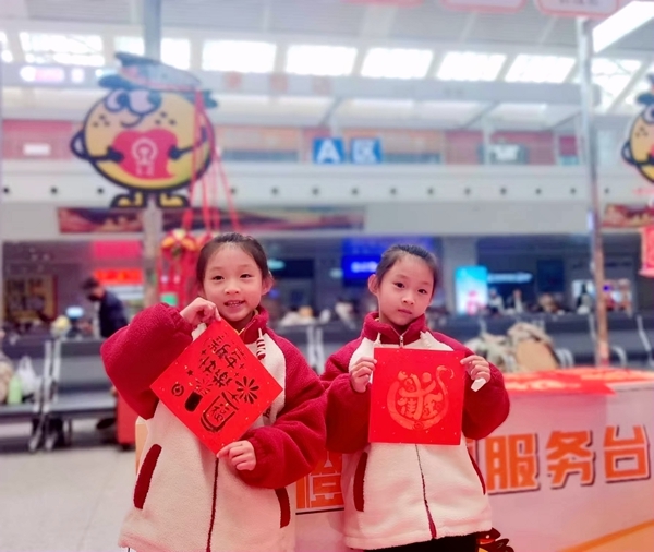圖四：春運(yùn)首日旅客，小朋友在展現(xiàn)自己的手工年畫(huà)。林建強(qiáng)攝