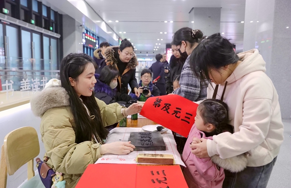 旅客在桂林站候車室體驗非物質(zhì)文化遺產(chǎn)“雕版印刷”活動 。鄭長賢攝