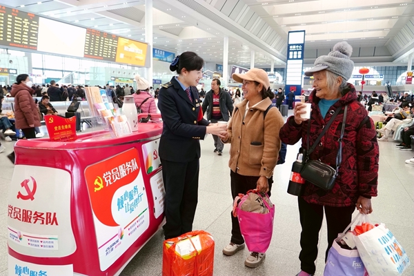 南寧東站工作人員為旅客送熱水。梁競輝攝