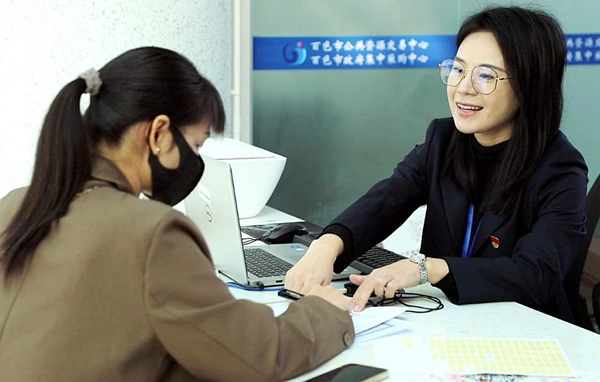 在百色市公共資源交易中心自助服務(wù)區(qū)，工作人員暖心為市民服務(wù)。百色市融媒體中心供圖