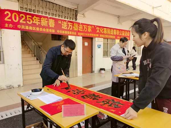 書法家正在為群眾書寫春聯(lián)。王信潔攝