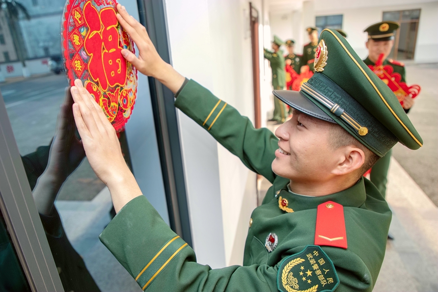 武警官兵張貼窗花扮靚軍營。