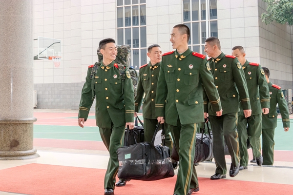 老兵幫助新兵搬運行李。