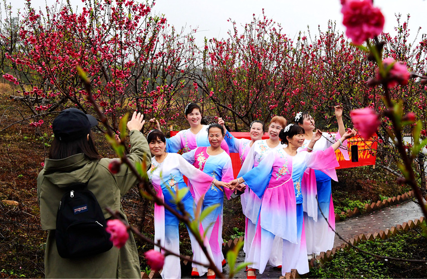 游客在羅城天河鎮(zhèn)彩虹谷桃花島內(nèi)留影。