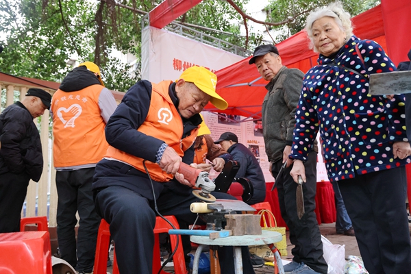 雷鋒街市志愿者在幫市民磨刀。戴佩蕓攝