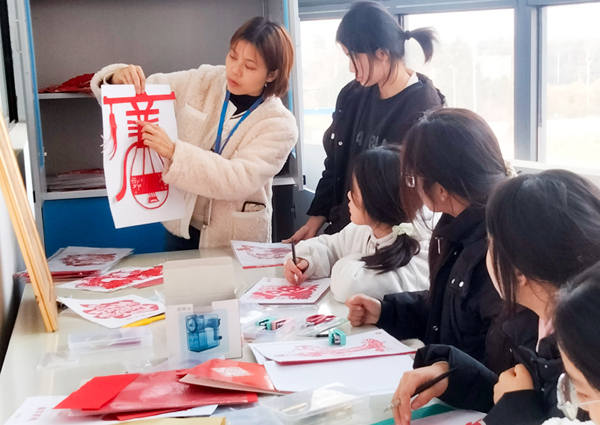 老師在課堂上做剪紙指導(dǎo)。