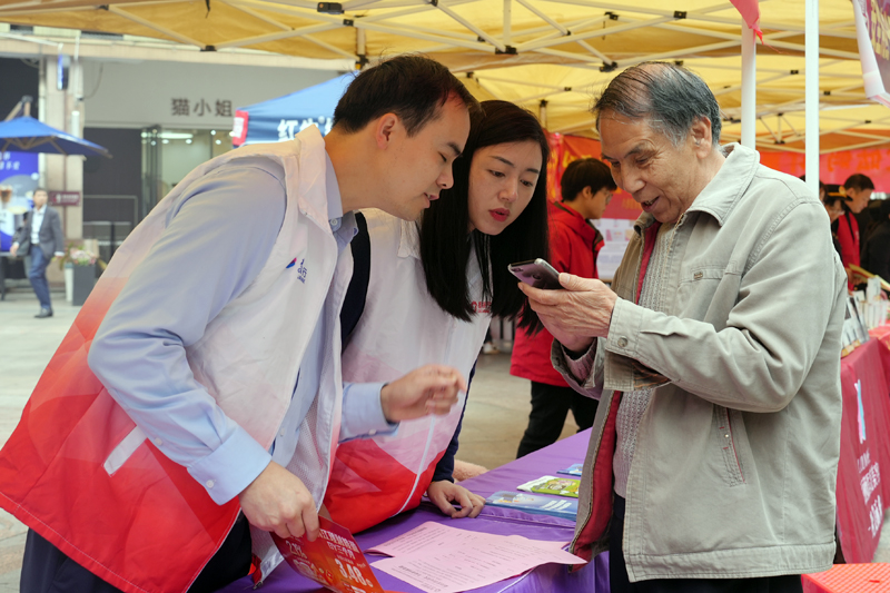 志愿者正在為市民答疑解惑，并積極宣傳消費(fèi)者維權(quán)知識(shí)。