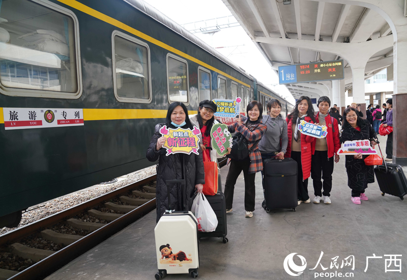 旅客與旅游專列合影留念。人民網(wǎng)記者 王勇攝