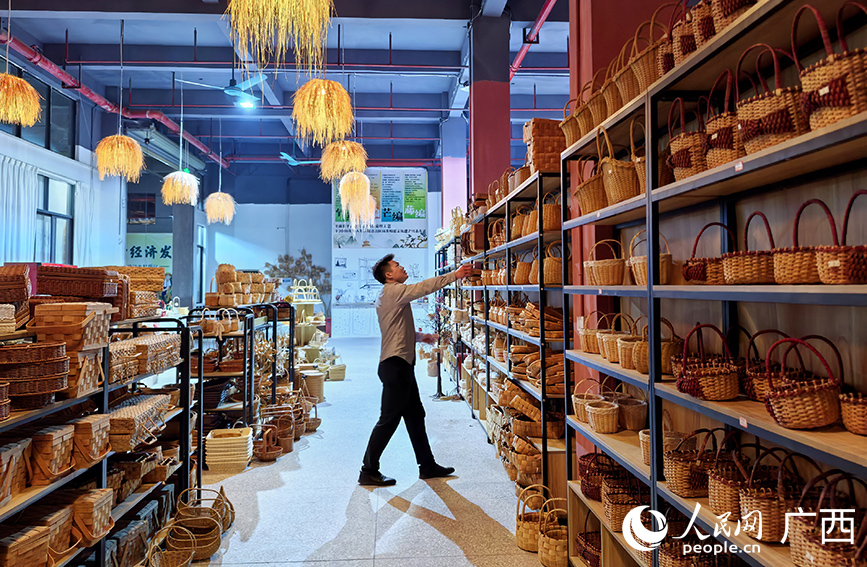 莫思明查看企業(yè)生產(chǎn)的非遺工藝品。人民網(wǎng) 付華周攝