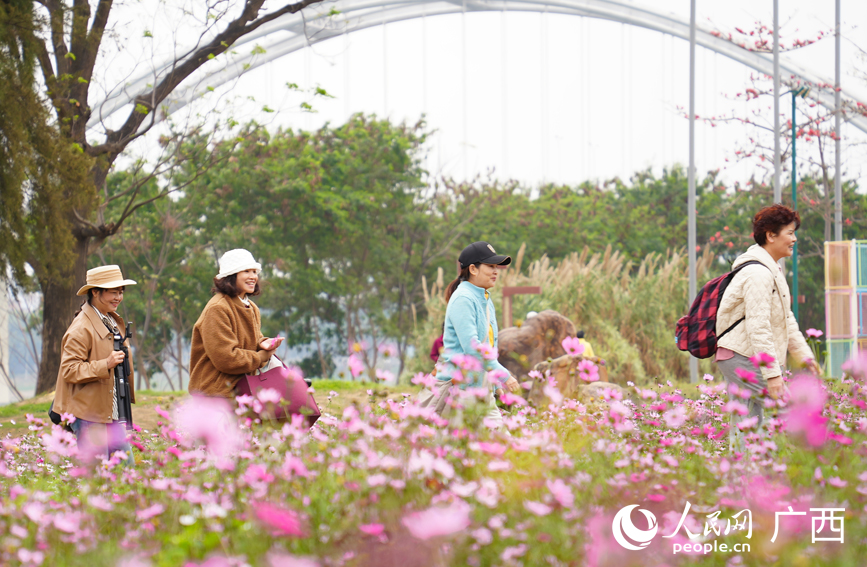 市民走進(jìn)公園感受春天的詩意與美好。