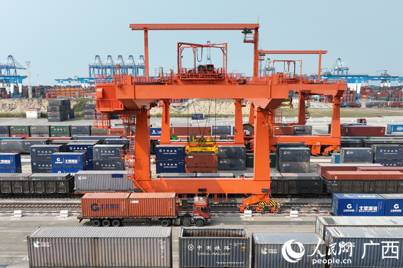 圖為廣西欽州鐵路集裝箱中心站內(nèi)，自動(dòng)化龍門吊正在吊裝汽運(yùn)集裝箱貨物。陳磊攝