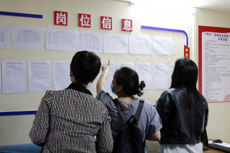 求職者在萬秀區(qū)“金牌就業(yè)管家”零工市場內(nèi)查看崗位信息。